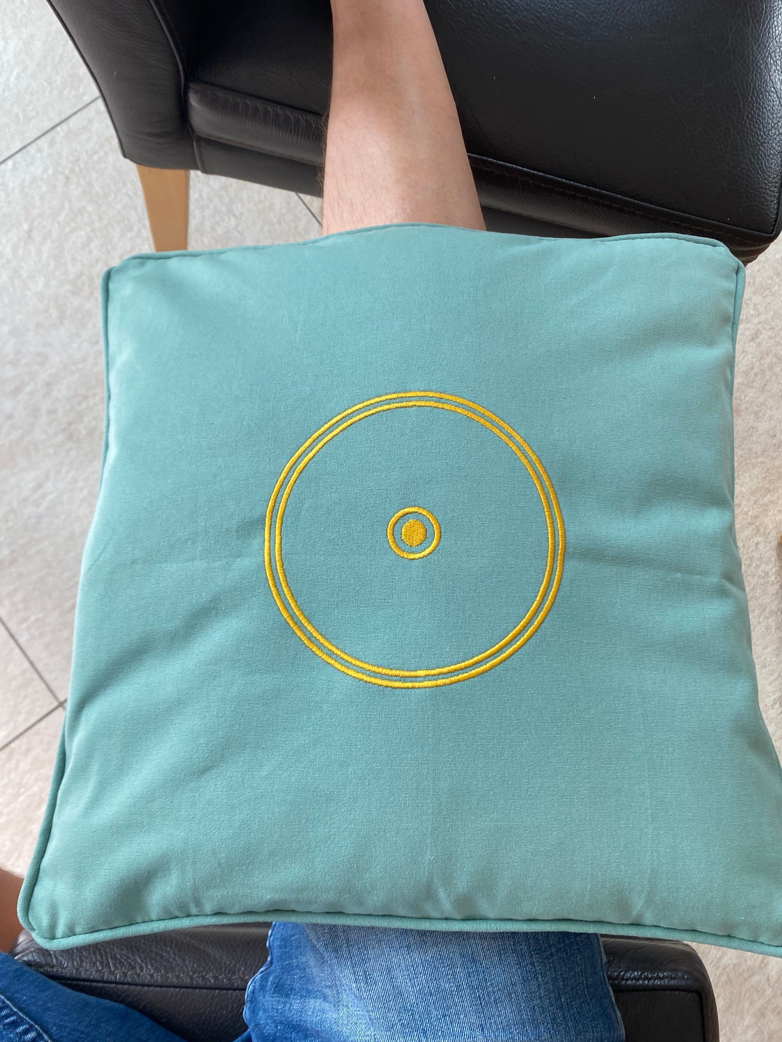 Orgon Kissen grün mit energetischem Schutz (Sonnensymbol) in der Anwendung