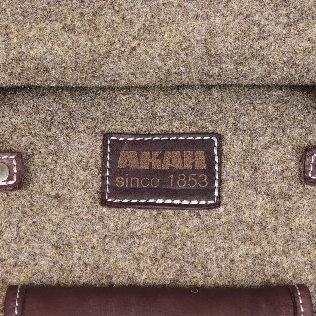 Es handelt sich hier um AKAH Rolltop-Rucksack aus Wollfilz und Olivenleder für die Jagd.