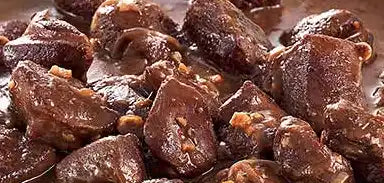 Stücke von dunkler Schokolade mit Nüssen, die verteilt sind.
