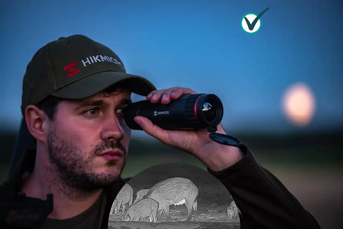 Person mit einer Hikvision-Mütze, die bei Dämmerung durch ein Fernglas schaut.